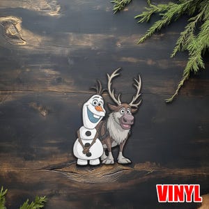 Puede incluir: Una pegatina de vinilo con los personajes Olaf el mu&ntilde;eco de nieve y Sven el reno de la pel&iacute;cula Frozen. Olaf es blanco con una nariz de zanahoria y botones negros. Sven es marr&oacute;n con grandes cuernos. La palabra "VINYL" est&aacute; en la esquina inferior derecha.