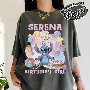 Peut inclure: Un t-shirt gris anthracite avec un motif du personnage Stitch portant un chapeau de f&ecirc;te. Le design comprend le texte SERENA, le chiffre 3 et BIRTHDAY GIRL, entour&eacute; de bo&icirc;tes cadeaux color&eacute;es, de ballons et d'un g&acirc;teau d'anniversaire.