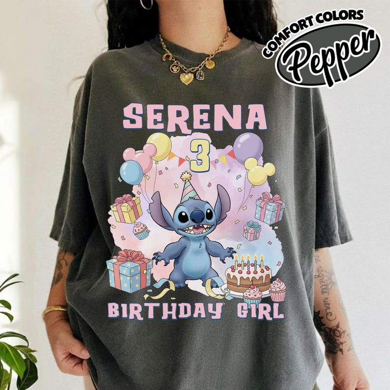 Peut inclure: Un t-shirt gris anthracite avec un motif du personnage Stitch portant un chapeau de f&ecirc;te. Le design comprend le texte SERENA, le chiffre 3 et BIRTHDAY GIRL, entour&eacute; de bo&icirc;tes cadeaux color&eacute;es, de ballons et d'un g&acirc;teau d'anniversaire.
