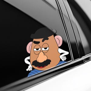 May include: A cartoon Mr. Potato Head sticker peeking out of a car window. The sticker features a brown face, black mustache, and a black hat. The character is wearing a blue striped shirt and has white hands.