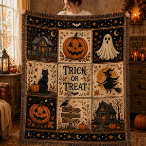May include: A rectangular woven throw blanket featuring a grid of Halloween-themed illustrations including a jack-o'-lantern, a ghost, a black cat, a witch on a broomstick, and houses. The center panel displays the text Trick or Treat.