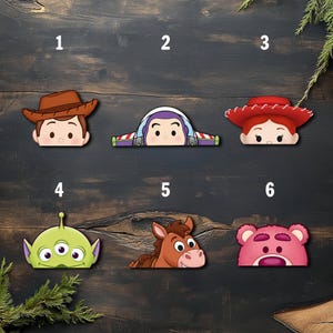 May include: A collection of six cartoon character face cutouts from the Toy Story franchise. The characters include Woody, Buzz Lightyear, Jessie, an alien, Bullseye, and Lotso. Each cutout is a different color and has a unique design.