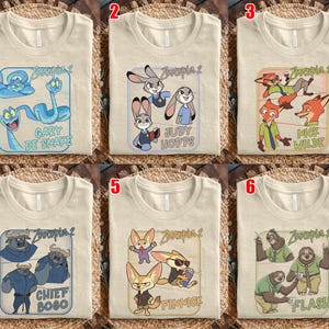 Pode incluir: Seis camisetas bege com diferentes designs de personagens de Zootopia 2. Cada camisa apresenta um gr&aacute;fico retangular com personagens como Gary De Snake, Judy Hopps, Nick Wilde, Chief Bogo, Finnick e Flash.