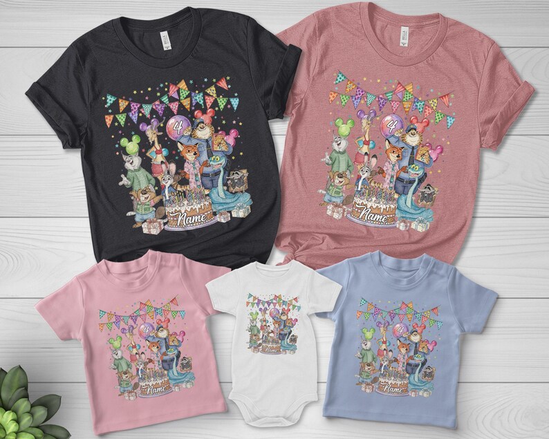 May include: A collection of t-shirts and a onesie in various colors, featuring a colorful cartoon design. The design includes a birthday cake, cartoon characters, balloons, and the word "Name". The shirts are in black, pink, and blue.