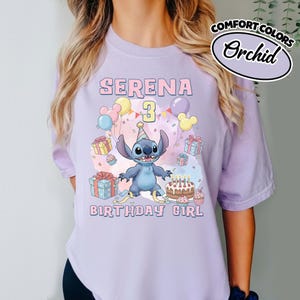 Peut inclure: Un t-shirt violet clair avec une illustration du personnage Stitch portant un chapeau de f&ecirc;te, entour&eacute; de ballons, de cadeaux et d'un g&acirc;teau d'anniversaire. Le texte indique SERENA, 3 et BIRTHDAY GIRL. Une &eacute;tiquette indique COMFORT COLORS Orchid.