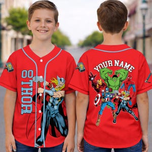 May include: Red baseball jersey featuring the superhero Thor with the number 00. The jersey has a light blue trim and the word "THOR" vertically down the front. The back of the jersey has the text "YOUR NAME" and images of other Marvel superheroes.