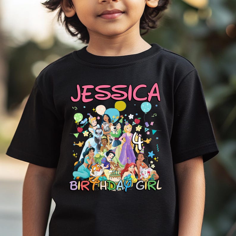 May include: Black t-shirt featuring the name "Jessica" in pink, with a colorful graphic of cartoon princesses and the number "4". The words "Birthday Girl" are also displayed in a colorful font.