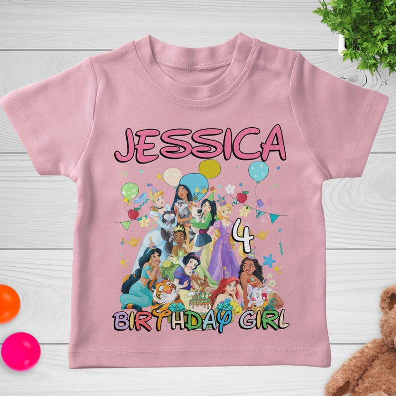 May include: Pink short-sleeved t-shirt with the name "JESSICA" in pink bubble letters. The shirt features a colorful graphic of Disney princesses, the number "4", and the words "BIRTHDAY GIRL".