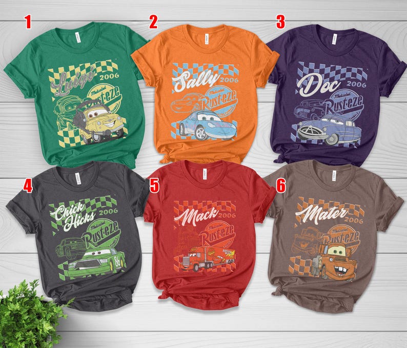May include: Six short-sleeved t-shirts in various colors, each featuring a graphic from the animated film "Cars." Designs include characters like Lightning McQueen, Sally, Doc Hudson, Chick Hicks, Mack, and Mater, with the "Rust-eze" logo.
