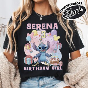 Peut inclure: Un t-shirt noir avec un motif repr&eacute;sentant un personnage extraterrestre bleu portant un chapeau de f&ecirc;te, entour&eacute; de ballons color&eacute;s, de cadeaux, de cupcakes et d'un g&acirc;teau d'anniversaire. Le texte indique SERENA 3 BIRTHDAY GIRL. &Eacute;tiquette Comfort Colors Black.