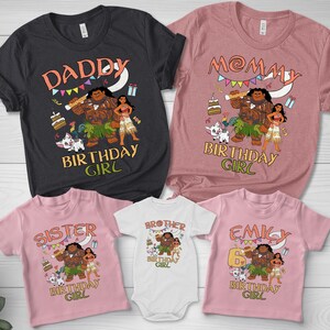 May include: A collection of five t-shirts and one baby bodysuit in black, mauve, and light pink. Each garment features a graphic print of characters from Moana, including Maui, Moana, and Pua, with text reading DADDY, MOMMY, SISTER, BROTHER, EMILY, and BIRTHDAY GIRL.