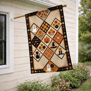 May include: A rectangular garden flag featuring a diamond-patterned quilt design in shades of orange, black, and cream. The print includes illustrations of a ghost, a black cat, a pumpkin, a witch hat, boots, flowers, and acorns with a button border.