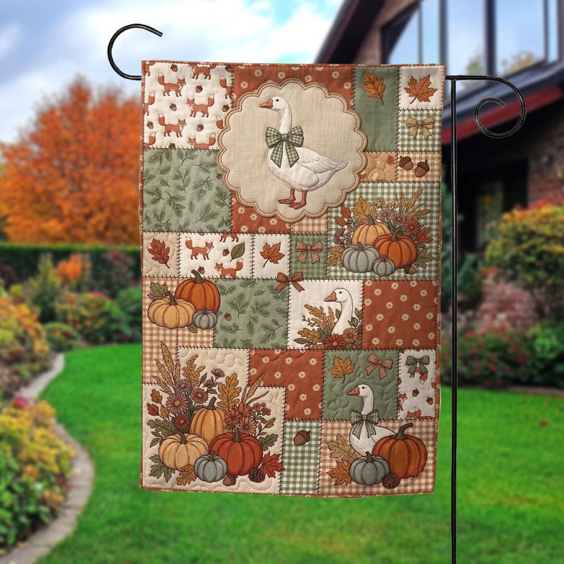 Pu&ograve; includere: Una bandiera da giardino rettangolare con un design patchwork a tema autunnale. La bandiera mostra illustrazioni di oche bianche con fiocchi verdi, zucche arancioni e verdi, volpi, ghiande e foglie autunnali nei toni del marrone e del verde.
