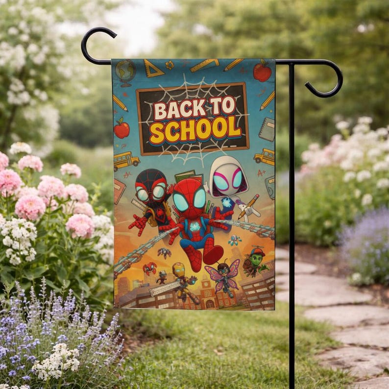 Puede incluir: Una colorida bandera de jard&iacute;n con personajes de Spider-Man y el texto "BACK TO SCHOOL". La bandera tiene un fondo azul con ilustraciones escolares. Est&aacute; colgada de un soporte de metal negro en un jard&iacute;n.