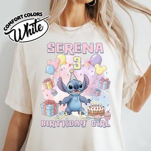 Peut inclure: Un t-shirt blanc cass&eacute; avec un motif du personnage Stitch portant un chapeau de f&ecirc;te, entour&eacute; de ballons, de cadeaux, d'un g&acirc;teau d'anniversaire et de cupcakes. Le texte indique SERENA 3 BIRTHDAY GIRL en lettres roses &agrave; contour bleu.