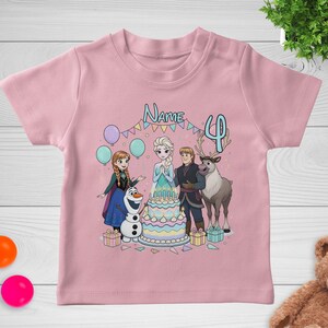 May include: Pink short-sleeved t-shirt featuring a colorful graphic of characters from a popular animated movie. The design includes a birthday cake, balloons, and the number 4. The word "Name" is also visible.
