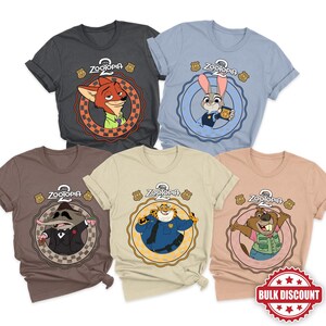 May include: Five Zootopia-themed t-shirts in various colors: charcoal, light blue, brown, tan, and peach. Each shirt features a different character from the movie within a circular design, with the Zootopia logo and police badge icons.