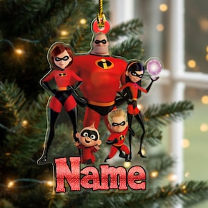 May include: A clear acrylic Christmas ornament featuring the Incredibles family. The ornament shows the characters in their superhero costumes, with the word "Name" in a glittery font at the bottom. A gold string is attached for hanging.