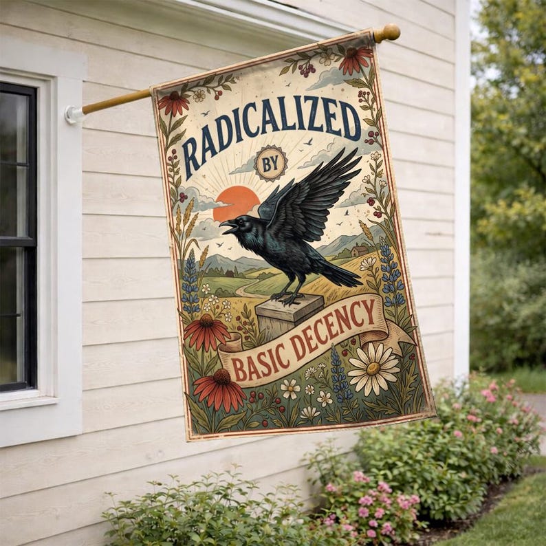 Może przedstawiać: Prostokątna flaga z napisem "RADICALIZED BY BASIC DECENCY" i grafiką czarnego kruka siedzącego na drewnianym bloku. Flaga ma estetykę vintage z elementami kwiatowymi i krajobrazowymi.