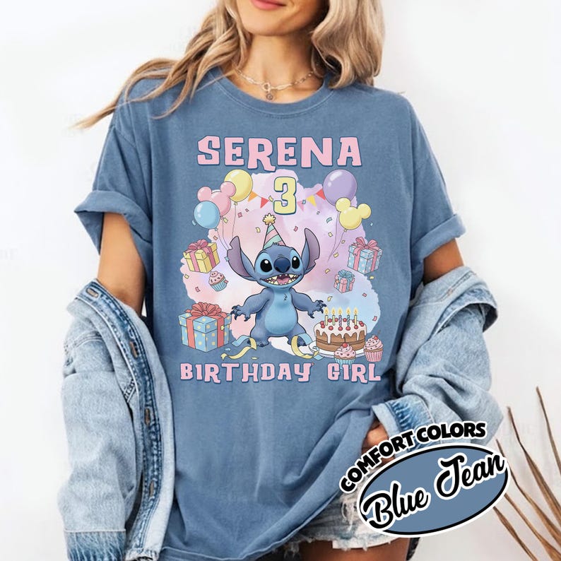 Peut inclure: Un t-shirt bleu jean avec une illustration du personnage Stitch portant un chapeau de f&ecirc;te, entour&eacute; de ballons, de cadeaux et d'un g&acirc;teau d'anniversaire. Le texte indique SERENA, le chiffre 3 et BIRTHDAY GIRL en lettres roses.