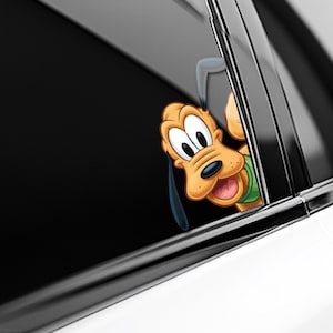 May include: A cartoon image of Pluto, the Disney dog, peeking out from a car window. Pluto is tan with black ears and a green collar. The car window is black and the car is white.