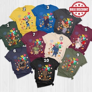 Puede incluir: Una colecci&oacute;n de diez camisetas de manga corta en varios colores, cada una con un dise&ntilde;o de personaje de dibujos animados con globos y fuegos artificiales coloridos. Las camisetas son en tonos de verde, amarillo, azul, gris, burdeos y negro.