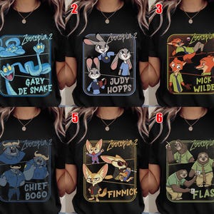Pode incluir: T-shirts pretas com personagens do filme "Zootopia 2". Cada camisa mostra um personagem ou grupo diferente, como Gary De Snake, Judy Hopps, Nick Wilde, Chief Bogo, Finnick e Flash, em designs coloridos.