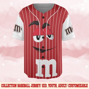Puede incluir: Camiseta de b&eacute;isbol a rayas rojas y blancas con un dise&ntilde;o de cara de dibujos animados. La camiseta tiene mangas blancas con el logo de "m&m's". La camiseta tiene una parte delantera abotonada y el texto "COLLECTION BASEBALL JERSEY/ KID, YOUTH, ADULT/ CUSTOMIZABLE" en la parte inferior.