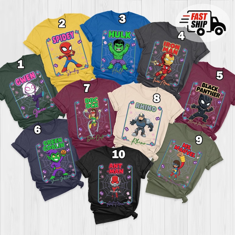 May include: Ten brightly coloured t-shirts, each showcasing a different superhero. The designs include characters like Spider-Man, Hulk, and Iron Man, with their names and associated imagery. The shirts are laid out on a flat surface, ready for display.