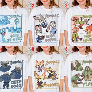 Pode incluir: T-shirts brancas com personagens do filme "Zootopia 2". Cada camisa mostra um personagem ou grupo diferente, como Gary De Snake, Judy Hopps, Nick Wilde, Chief Bogo, Finnick e Flash, em designs coloridos.