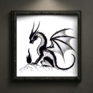 May include: A framed black and white illustration of a dragon. The dragon is depicted in a seated position with its wings spread, and a small flame is in front of it. The artwork is framed in a black, ornate frame.