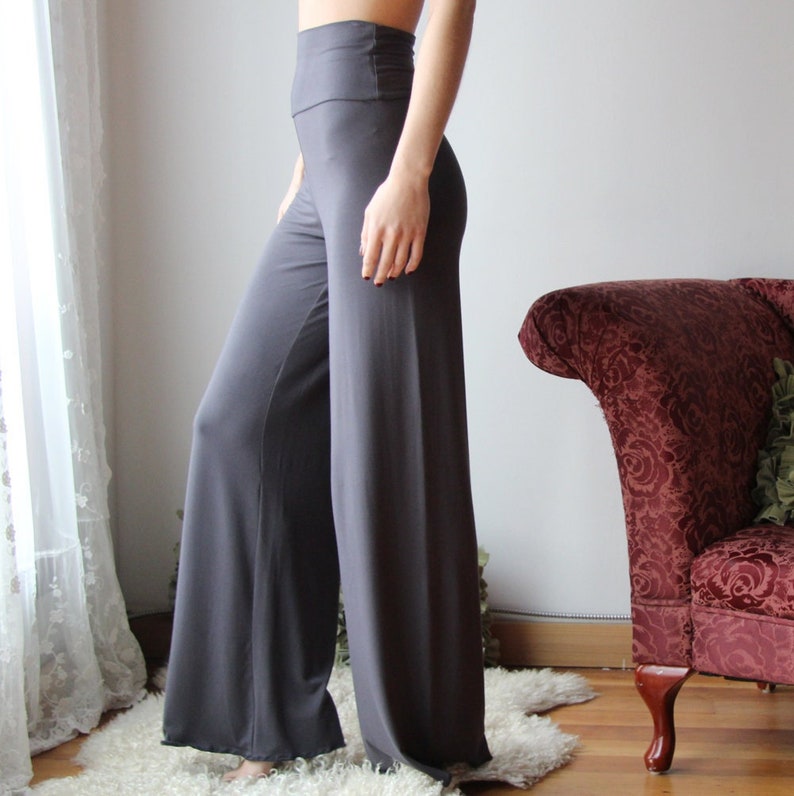K&ouml;nnte beinhalten: Graue, weite Hose mit hoher Taille. Die Hose ist aus einem weichen, dehnbaren Stoff gefertigt und hat eine flie&szlig;ende Silhouette.