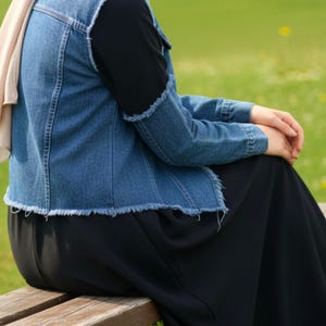 May include: A white ceramic mug with a black handle and the text "But First, Coffee" in a bold, black font. The mug is set against a neutral background, highlighting its simple design.