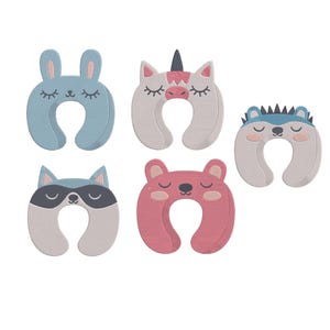 Puede incluir: Cinco almohadas de viaje en forma de U con diseños de animales. Incluyen un conejo azul, un unicornio, un erizo, un mapache y un oso rosa. Cada almohada tiene los ojos cerrados y están diseñadas para viajar.