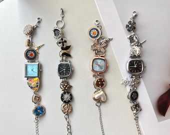 May include: Four decorative charm bracelets with square-faced watches and various charms. The bracelets feature silver, gold, and rose gold tones, with charms including flowers, hearts, stars, and other decorative elements. The watch faces are light blue, black, and brown.