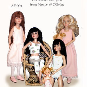 Könnte beinhalten: Bild von Puppen in verschiedenen Outfits, darunter Kleider, Camisoles und Leggings. Der Text "Under Things" und "AF 004" sind sichtbar. Die Puppen haben verschiedene Größen und Haarfarben, und eine sitzt in einem Korbstuhl.