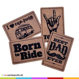 Könnte beinhalten: Vier braune Lederpatches mit schwarzem Text und Designs. Die Patches zeigen die Sätze "Ich liebe Camping", "Born to Ride", "Bester Papa aller Zeiten" und eine Hand, die das Rock'n'Roll-Zeichen macht.