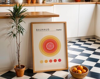 May include: A framed print with a minimalist design featuring a grapefruit slice in a circle of yellow, orange, and red concentric rings. The print has the text "Bauhaus" and "Grapefruit" in black lettering.