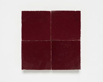 May include: Four square burgundy ceramic tiles arranged in a grid pattern.