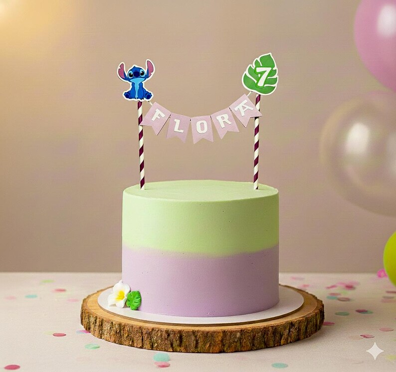 May include: A two-toned cake with green and purple frosting, decorated with a Stitch cake topper and a banner that reads "FLORA". The cake sits on a wooden cake stand and is decorated with a flower.