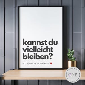 Peut inclure: Impression noir et blanc avec le texte "kannst du vielleicht bleiben?" en gras. Le texte est suivi de "SO UNGEFÄHR FÜR IMMER?!" en plus petit avec un symbole de cœur rouge. L'impression est encadrée d'un cadre noir et est accrochée à un mur gris.