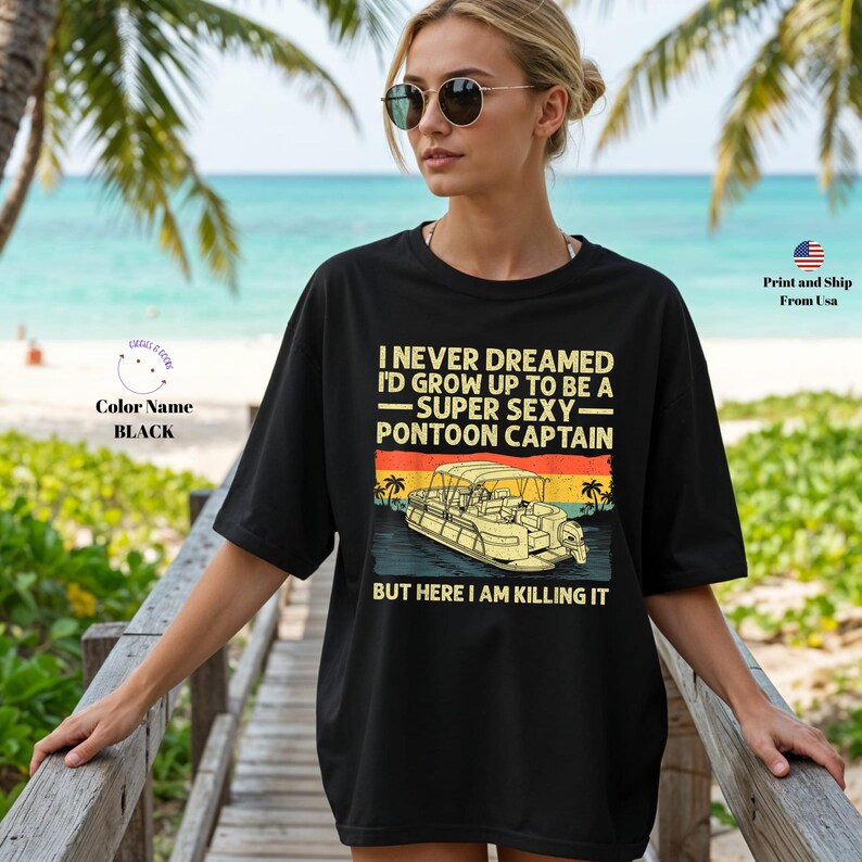 K&ouml;nnte beinhalten: Schwarzes T-Shirt mit dem Text "I NEVER DREAMED I'D GROW UP TO BE A -SUPER SEXY- PONTOON CAPTAIN BUT HERE I AM KILLING IT" und einer Grafik eines Pontonboots. Die Person tr&auml;gt eine Sonnenbrille.