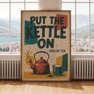 以下が含まれることがあります： 「PUT THE KETTLE ON」と「ENGLISH TEA」の太い暗い文字が書かれた長方形のウォールアートプリント。イラストには、蒸気が立ち上る赤いティーケトルと、黄色い太陽と幾何学模様を背景にしたティールカラーのマグカップが描かれています。