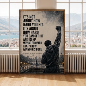 Puede incluir: Una lámina de arte mural rectangular que muestra a una persona con chaqueta con capucha y un brazo levantado en señal de victoria. El fondo muestra una ciudad al atardecer. El texto dice: IT'S NOT ABOUT HOW HARD YOU HIT. IT'S ABOUT HOW HARD YOU CAN GET HIT AND KEEP MOVING FORWARD. THAT'S HOW WINNING IS DONE. THE UNDERDOG, THE FIGHTER, THE CHAMPION, YOU.