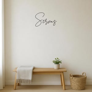 May include: A minimalist interior scene featuring a wooden bench with a light-colored throw blanket and a small potted plant. A woven basket sits on the floor. The word "Serving" is written in cursive on the wall.
