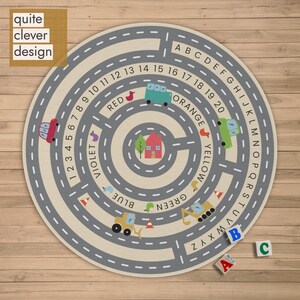 May include: A round children's play rug with a road design, numbers, letters, and colorful illustrations of vehicles and houses. The rug has the text "quite clever design". Includes ABC blocks.