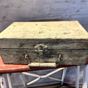 May include: A vintage wooden box with a metal latch and handle. The box is painted white and has a distressed look.