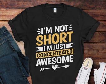May include: Black t-shirt with white text that reads "I'm not short I'm just concentrated awesome" with a white arrow and heart graphic.