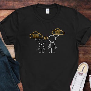May include: Black t-shirt with a humorous graphic. The design features stick figures and text bubbles. One bubble says "DAD WHAT ARE CLOUDS MADE OF?" and the other says "LINUX SERVERS MOSTLY".