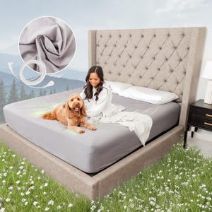 May include: A gray fitted sheet covers a bed with a tufted headboard. A woman and a dog are on the bed. A close-up shows the sheet's fabric and a cable. The bed is in a room with a lamp and a nightstand.